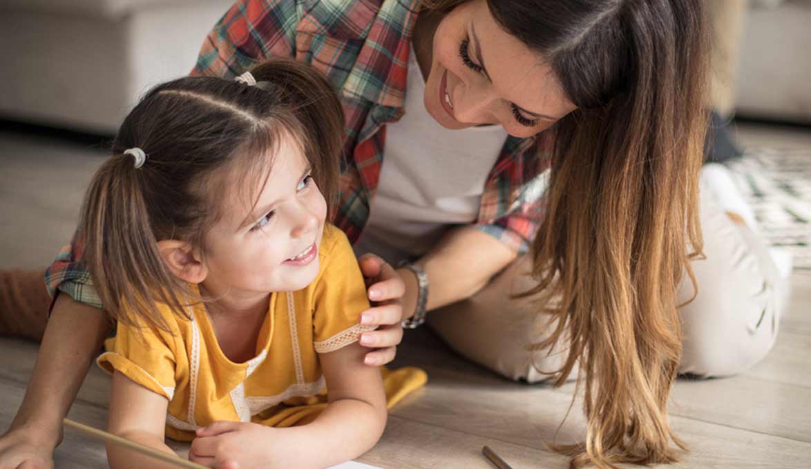 Mom and daughter playing on the floor.